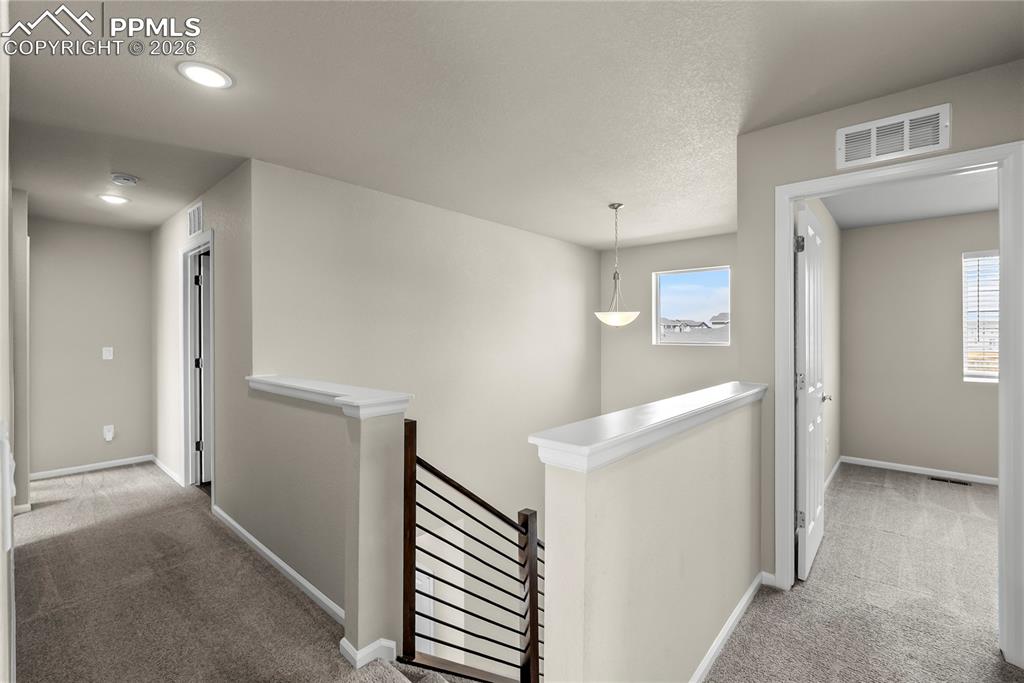 Image 12 of 43: Hallway featuring light carpet, an upstairs landing, and a recessed lightin
