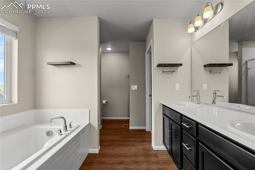 Image 16 of 43: En-Suite 5 piece bath with double vanity, bath tub, shelving, and free stan
