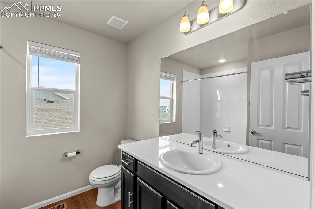 Image 21 of 43: Upper Level Full bath featuring vanity, plenty of natural light, and a show