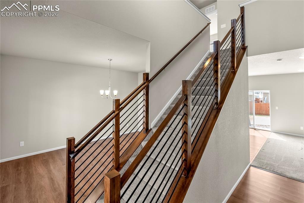 Image 4 of 43: Stairs with wood finished floors and hanging lights