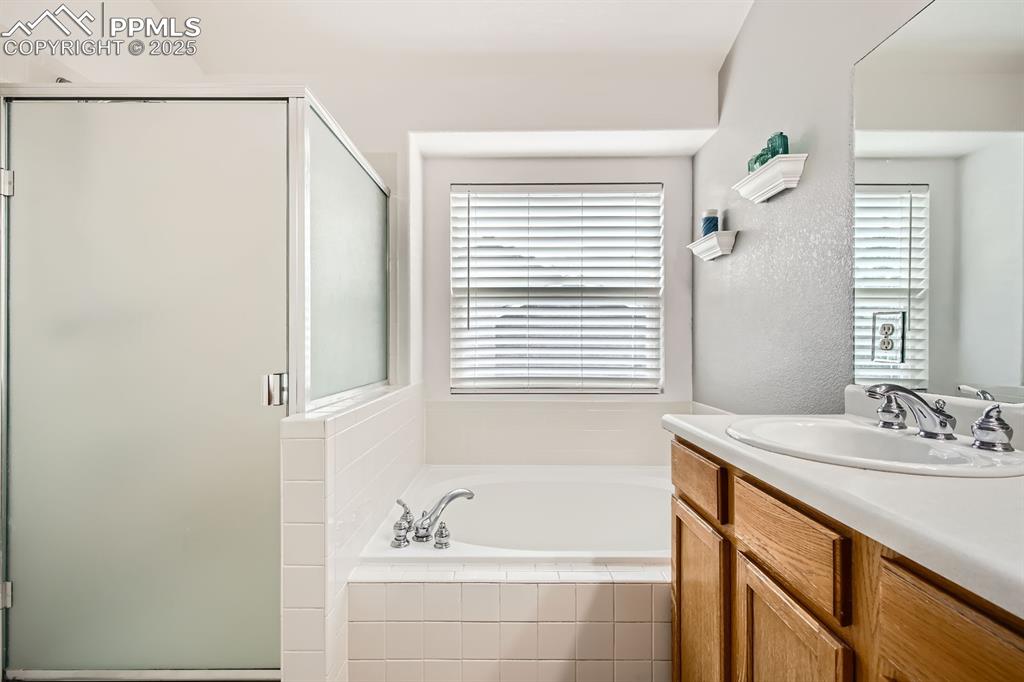 Image 10 of 18: Full bath featuring vanity, a garden tub, and a stall shower