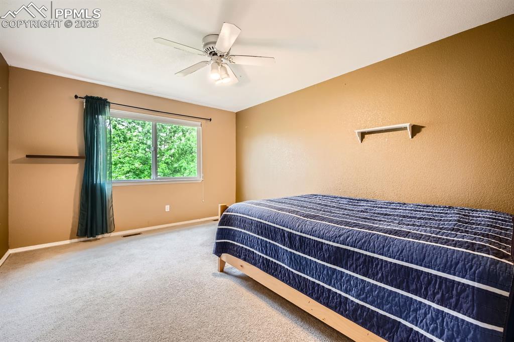 Image 12 of 18: Carpeted bedroom with baseboards and ceiling fan