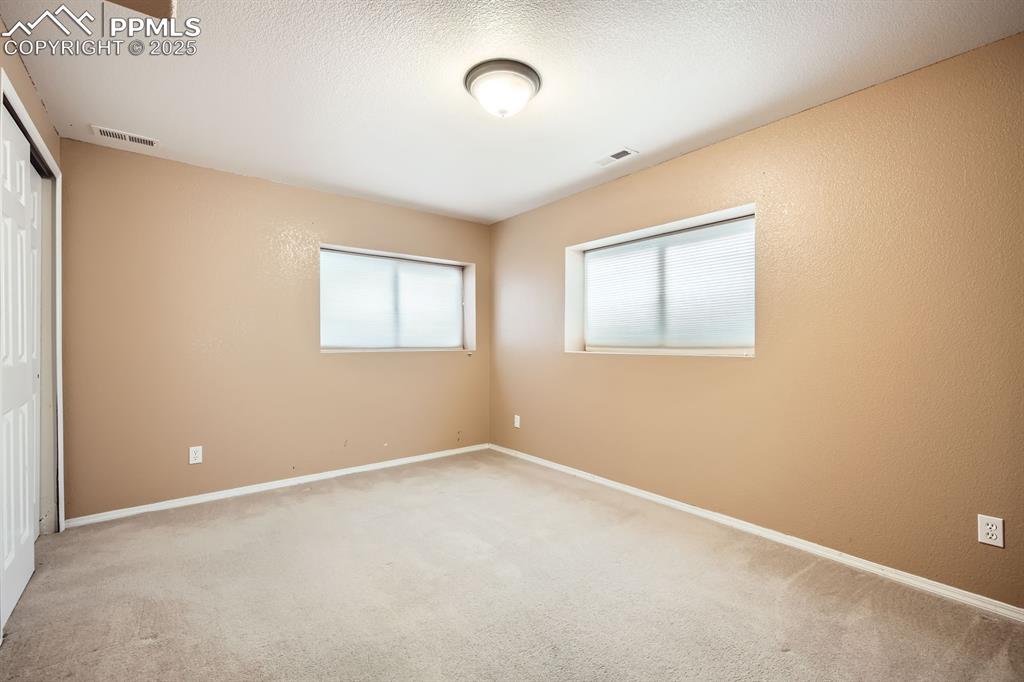 Image 15 of 18: Spare room featuring light carpet and a textured ceiling