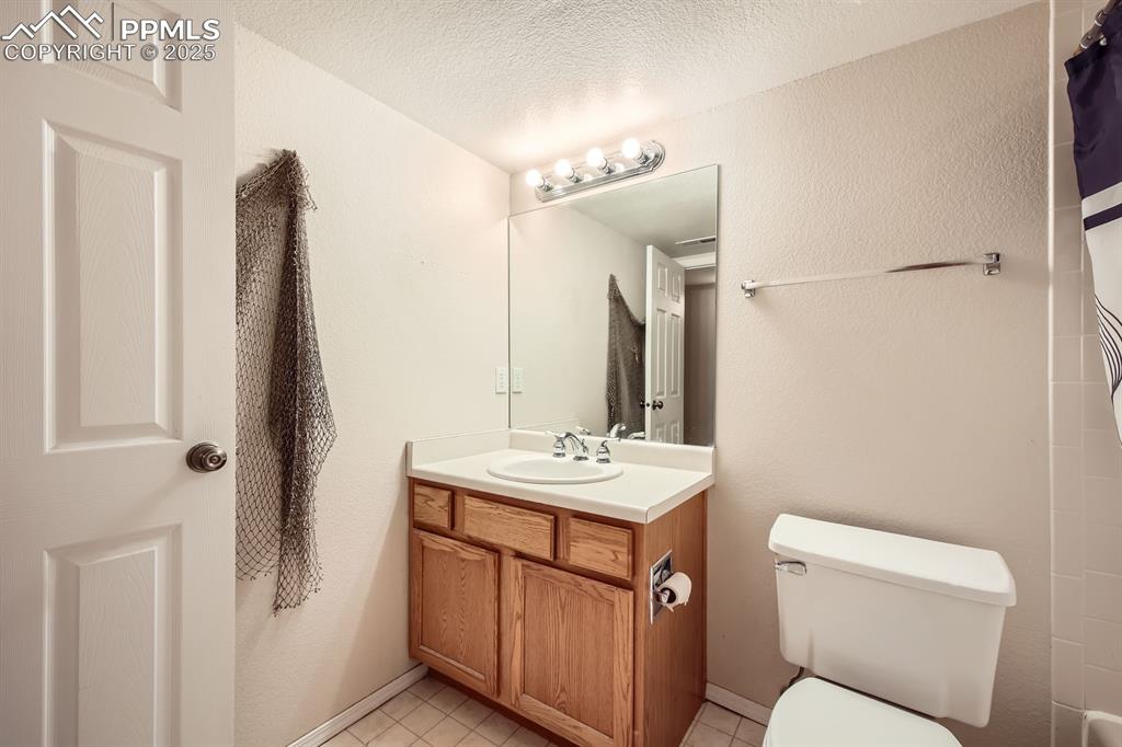 Image 16 of 18: Full bath featuring vanity, a shower with shower curtain, tile patterned fl