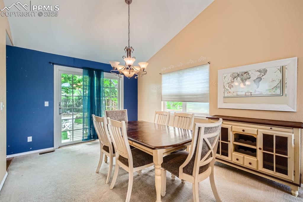 Image 3 of 18: Dining room featuring a chandelier, carpet flooring, and high vaulted ceili