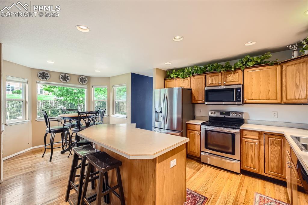 Image 4 of 18: Kitchen with stainless steel appliances, light countertops, light wood-styl