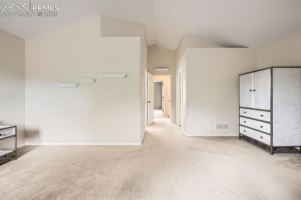 Image 9 of 18: Unfurnished bedroom featuring light colored carpet and high vaulted ceiling
