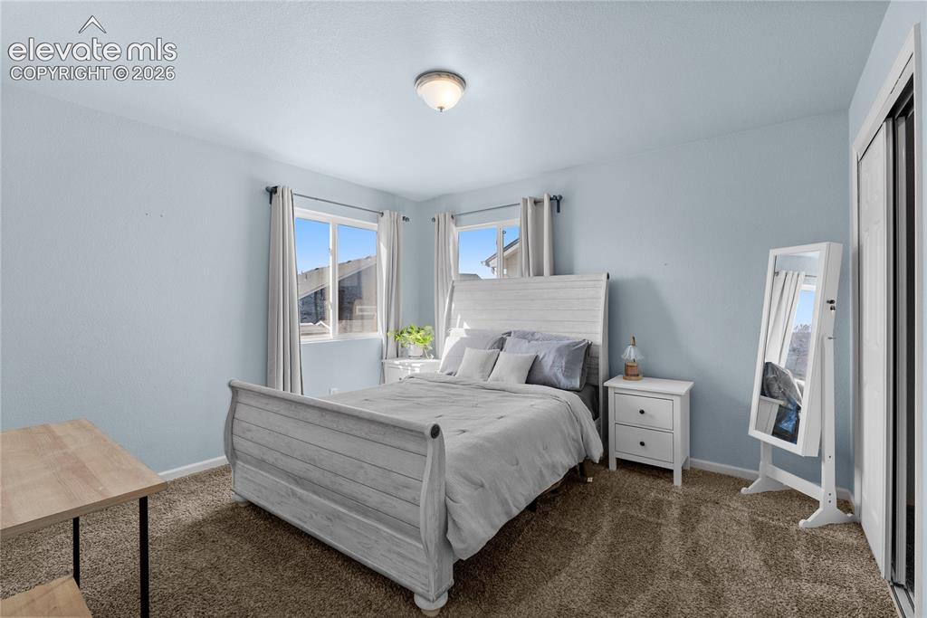 Image 10 of 42: Plush carpet flooring, a built-in closet with sliding doors, and a ceiling-