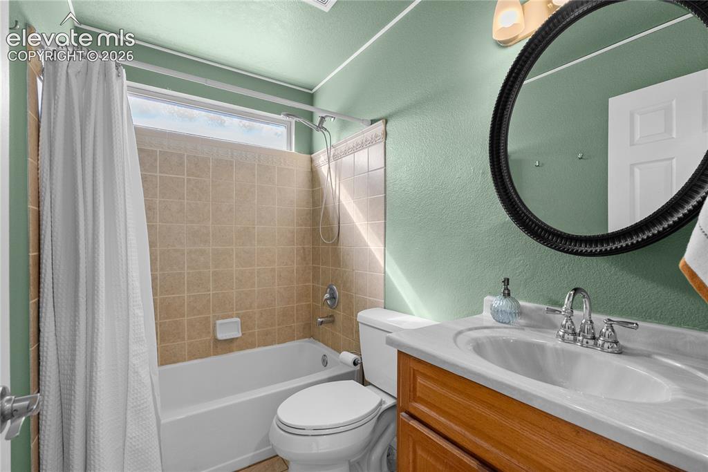 Image 13 of 42: Bathroom with a built-in tub, tiled shower surround, and upper transom wind