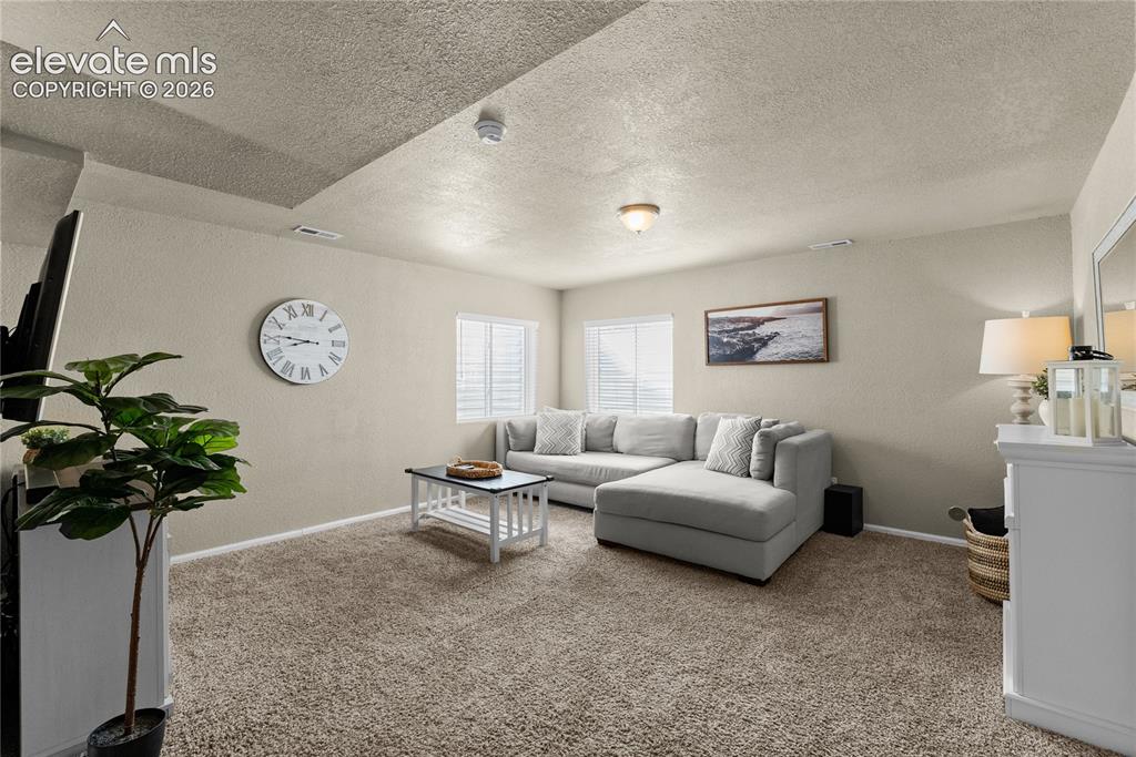 Image 16 of 42: Carpeted flooring throughout, recessed lighting, and windows with blinds