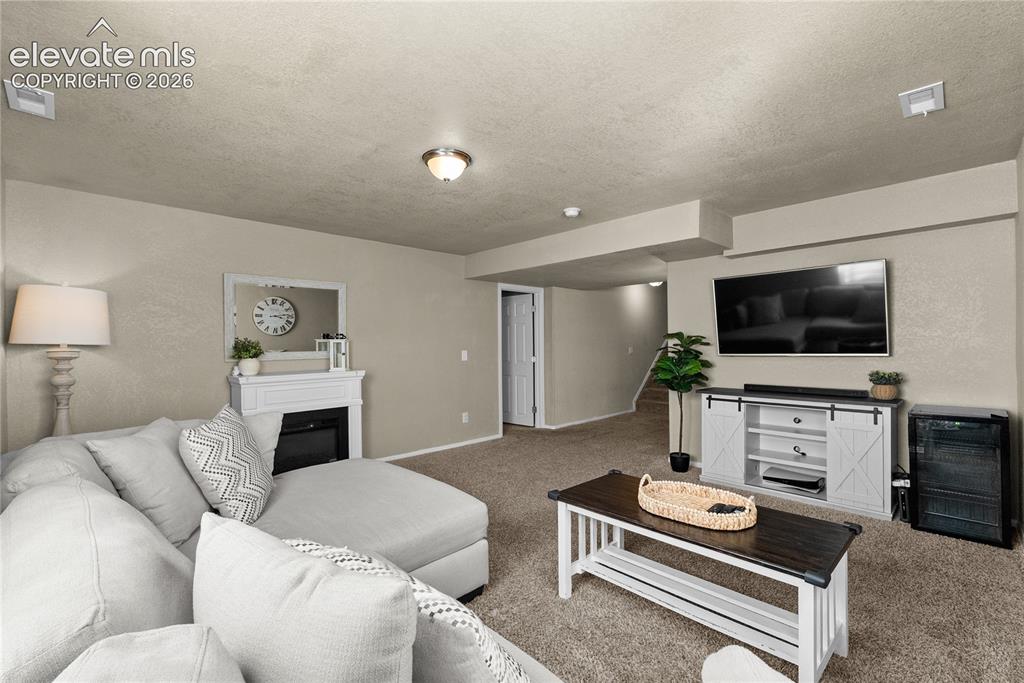 Image 18 of 42: Carpeted flooring, recessed ceiling lighting, wall-mounted television, buil