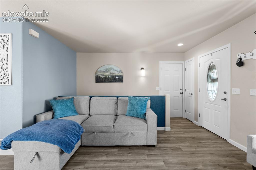Image 28 of 42: Wood-finish flooring throughout, featuring a white paneled entry door with 