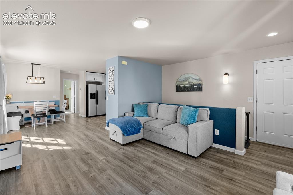 Image 29 of 42: Wood-finish flooring throughout, recessed ceiling lighting, and a modern re