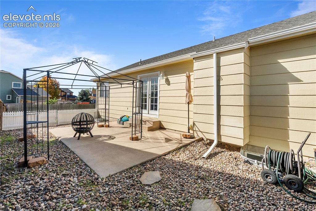 Image 30 of 42: Rear exterior with light-colored siding and a concrete patio