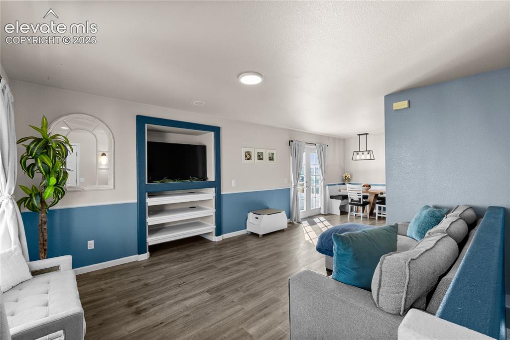 Image 4 of 42: Wood-finish flooring, built-in entertainment center with shelving, recessed