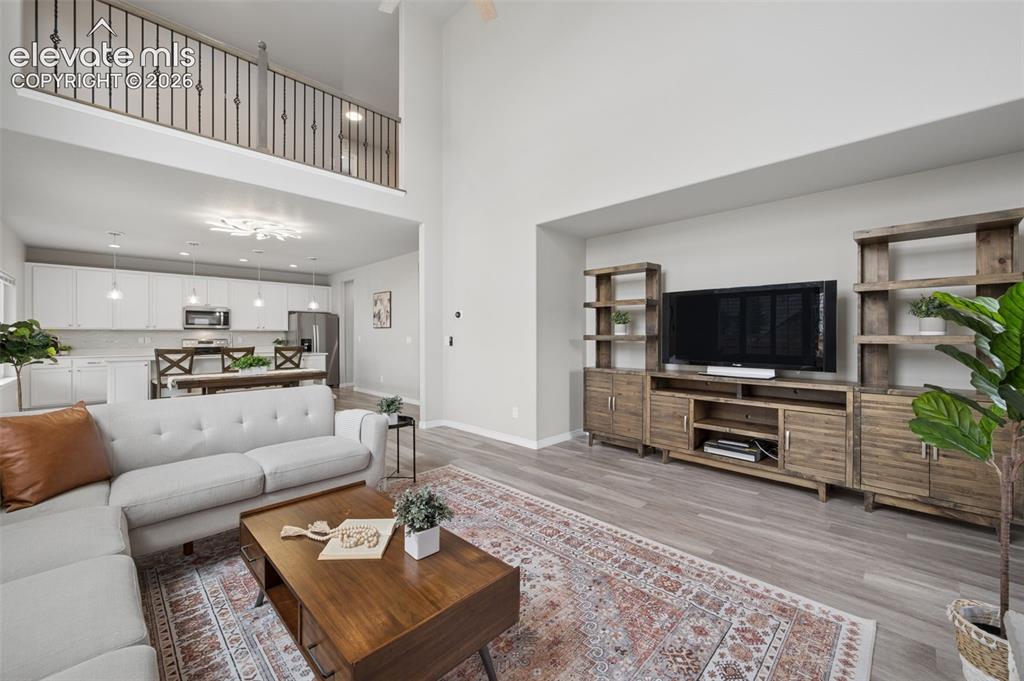 Image 11 of 43: Open-concept living space with high ceilings and wood-finish flooring