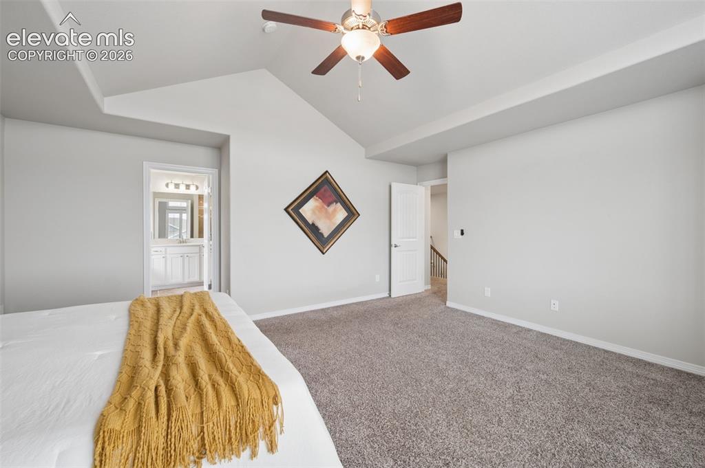 Image 17 of 43: Vaulted ceiling with an attached ceiling fan, neutral wall paint, and gray