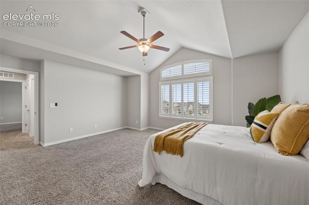Image 18 of 43: Vaulted ceiling with a ceiling fan, arched window with plantation shutters,