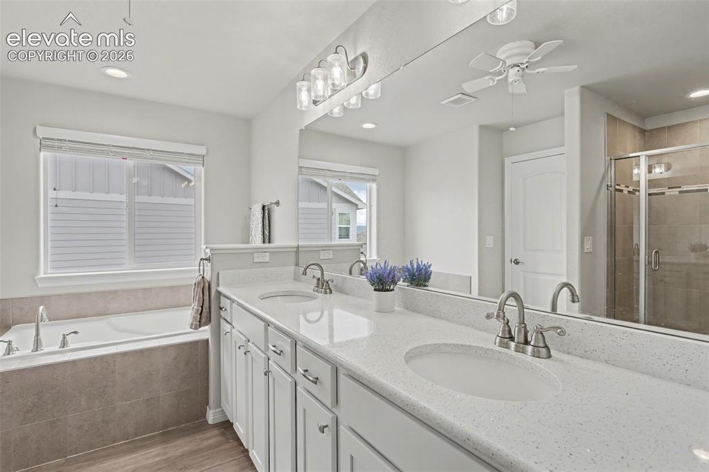 Image 19 of 43: Dual vanity with integrated sinks, white cabinetry, and light-toned counter