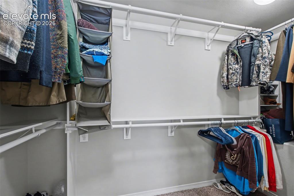 Image 21 of 43: Customizable closet system featuring multiple hanging rods and shelving