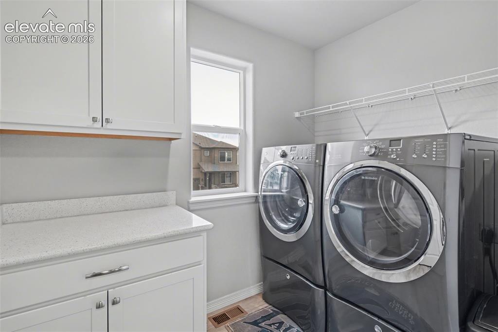 Image 22 of 43: White cabinetry with chrome hardware, light-toned countertop, and window