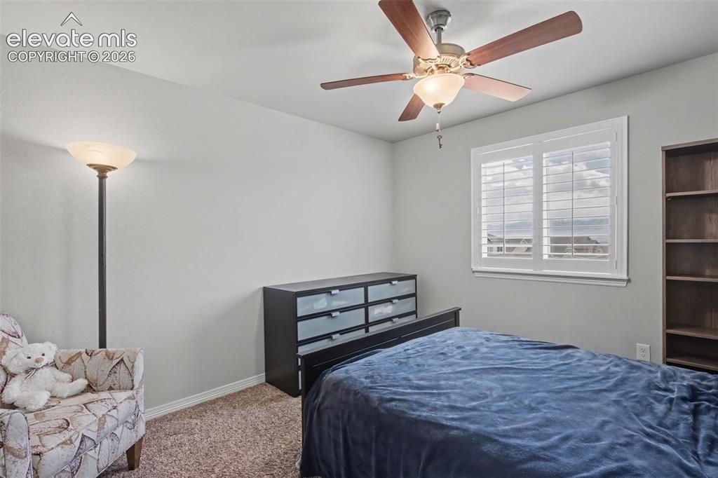 Image 26 of 43: Window with louvered shutters, ceiling fan with integrated lighting, built-