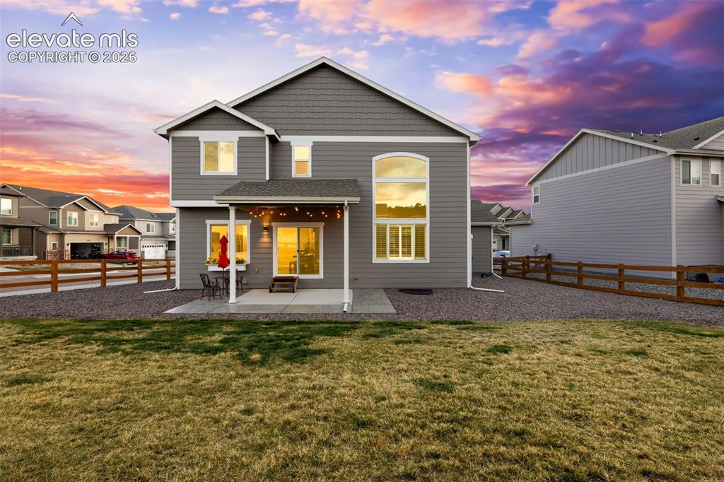 Image 3 of 43: Rear exterior featuring gray siding, a covered patio, sliding glass doors,