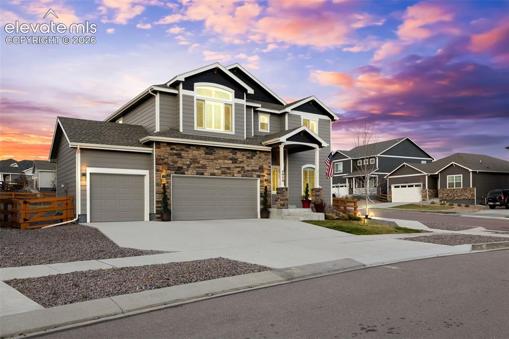 Image 31 of 43: Contemporary exterior with a stone and siding facade, covered front entry,