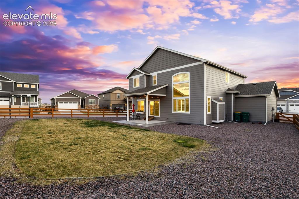 Image 32 of 43: Gray siding exterior with white trim, large picture windows, covered patio,
