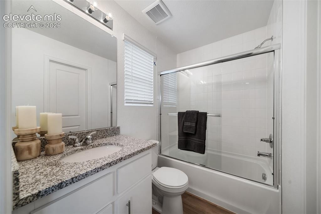 Image 18 of 25: Photos of a Model Home: Bathroom featuring a white vanity with a granite co