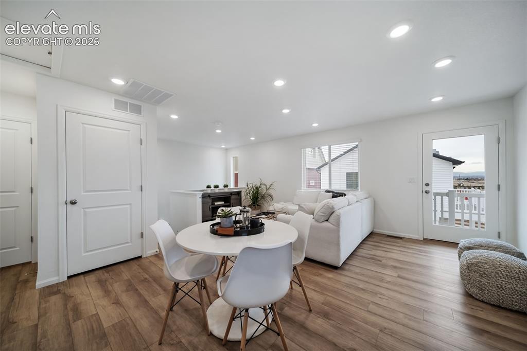 Image 3 of 25: Open-concept living area featuring wood-finish flooring, recessed lighting,