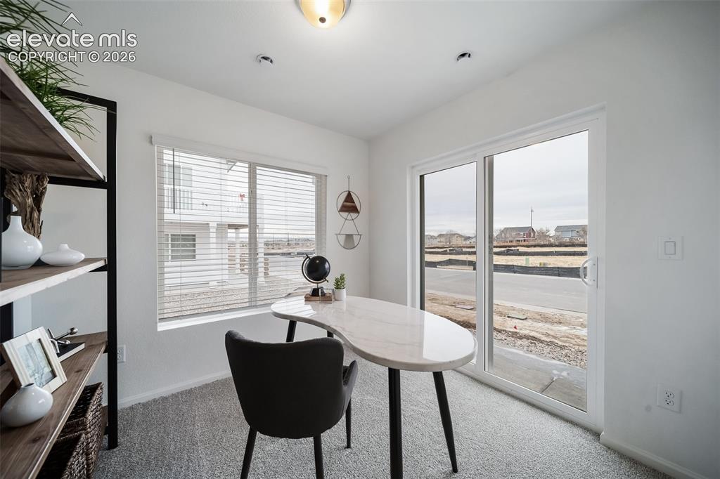 Image 6 of 25: Bright interior space featuring a window with blinds, a sliding glass door,