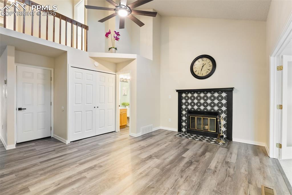 Image 15 of 50: Unfurnished living room with high vaulted ceiling, light wood-style floorin