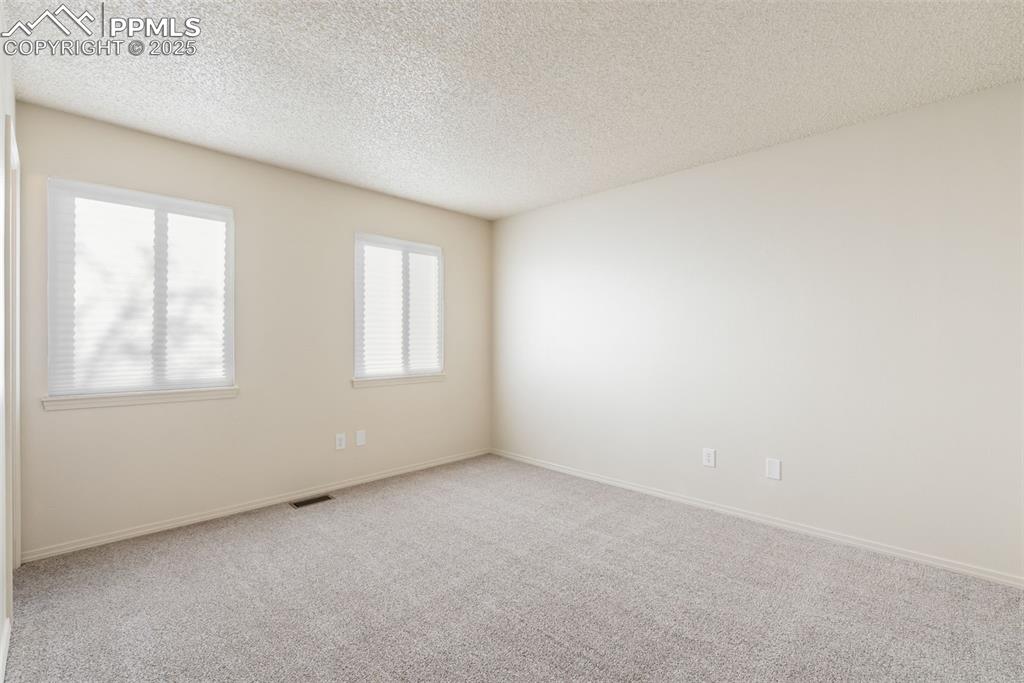 Image 28 of 50: Carpeted spare room featuring a textured ceiling and baseboards