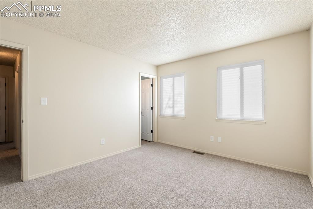 Image 29 of 50: Carpeted spare room with a textured ceiling and baseboards