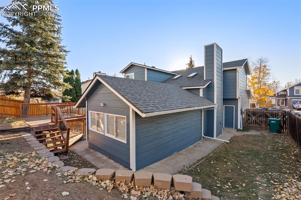 Image 37 of 50: View of side of property featuring a shingled roof, a fenced backyard, a ch