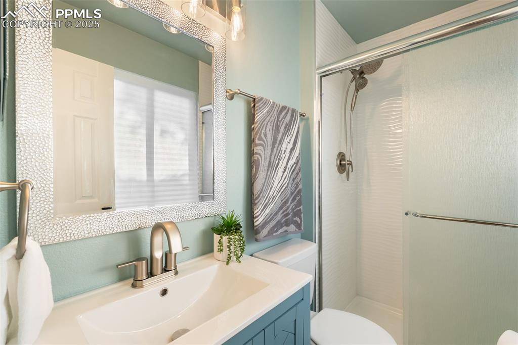 Image 4 of 50: Bathroom with vanity and a stall shower