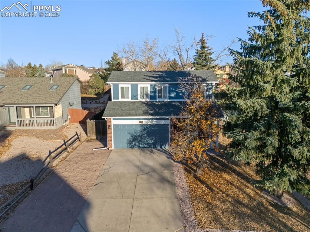 Image 45 of 50: View of front facade with concrete driveway, a garage, a shingled roof, and