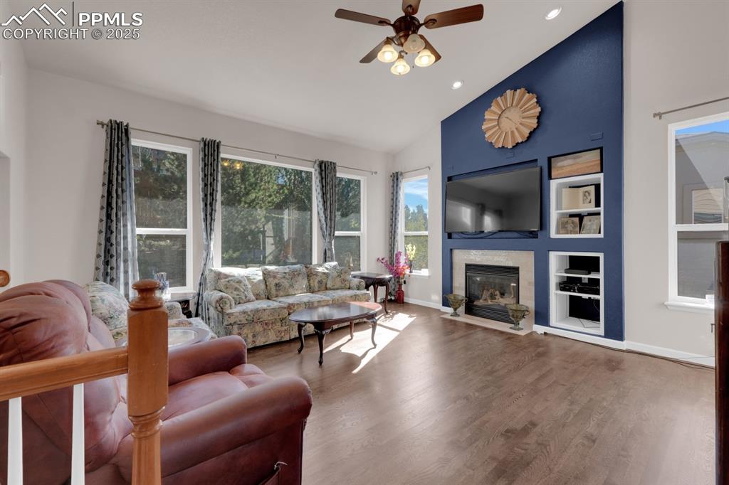 Image 3 of 43: Living room featuring built ins, hardwood floors, a gas fireplace, a ceilin