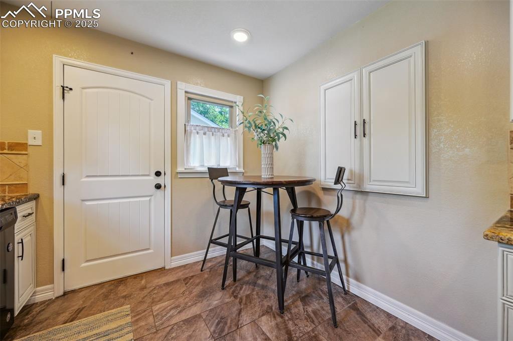 Image 10 of 31: the kitchen has a dining nook, and access to the backyard.