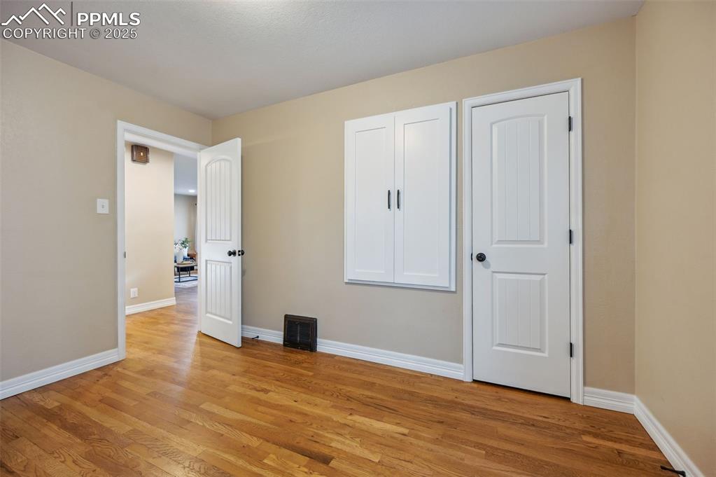 Image 17 of 31: Main level bedroom #2 has a walk-in closet and built in storage cabinet.
