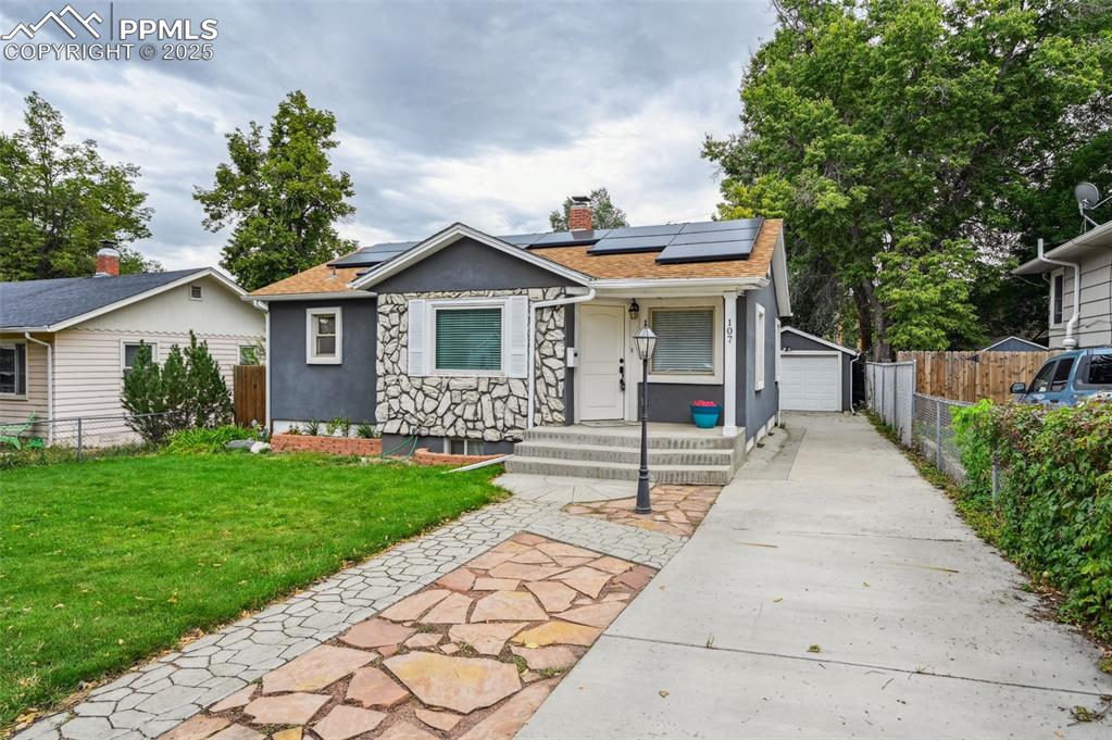 Image 2 of 31: This home has a stucco and stone exterior, a walking path and it