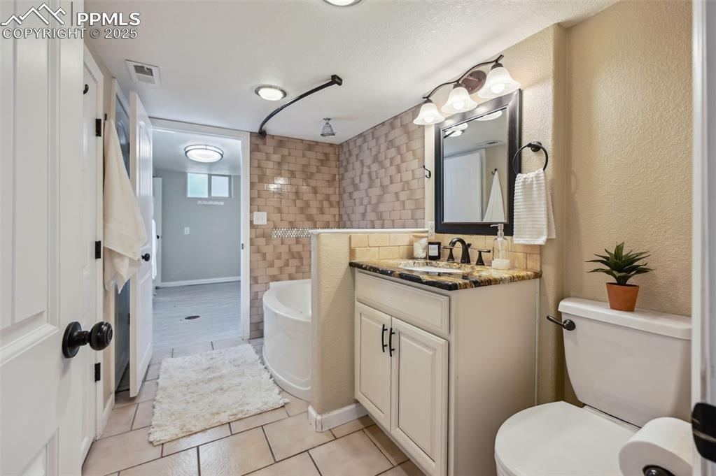 Image 24 of 31: Full bathroom located in the basement and adjoins to the primary bedroom an