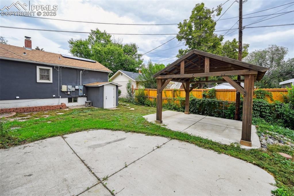 Image 28 of 31: Spacious backyard has a pavilion and two concrete pads for entertaining.