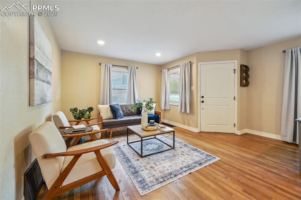 Image 3 of 31: Main level living room has hardwood floors and large windows.