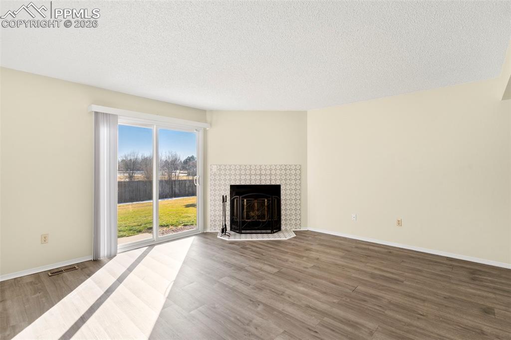 Image 4 of 17: Featuring a walk-out to the backyard and wood burning fireplace