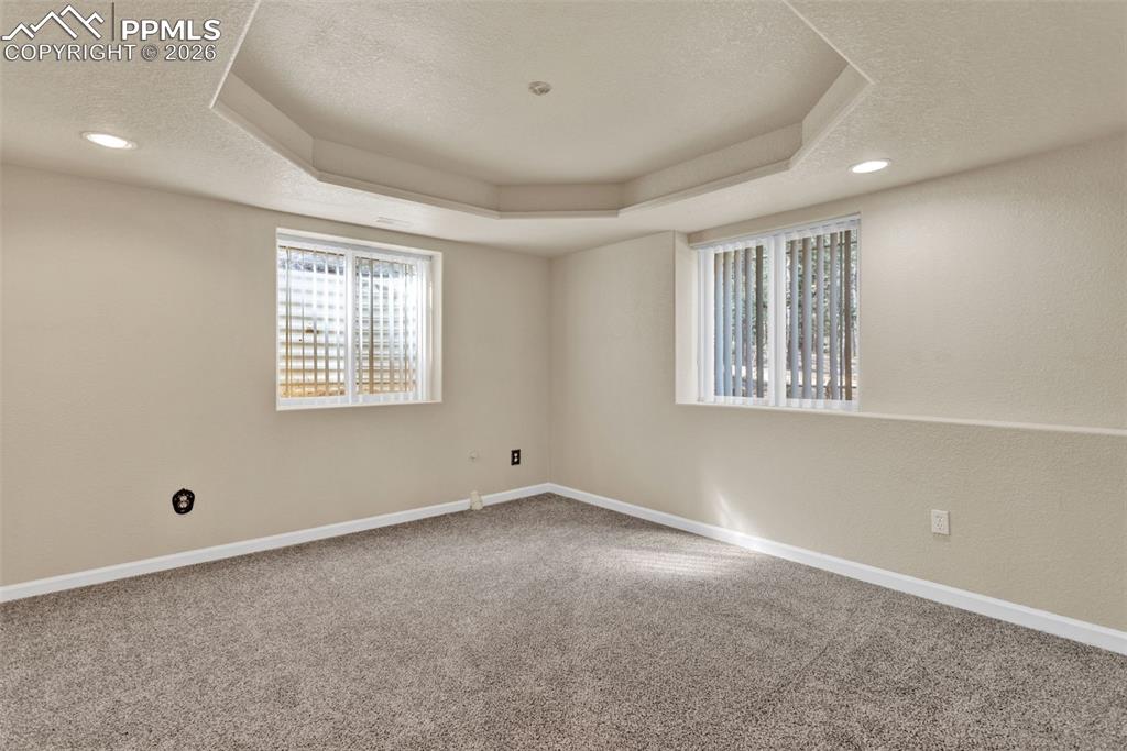Image 26 of 30: Basement open area with doors to bedrooms