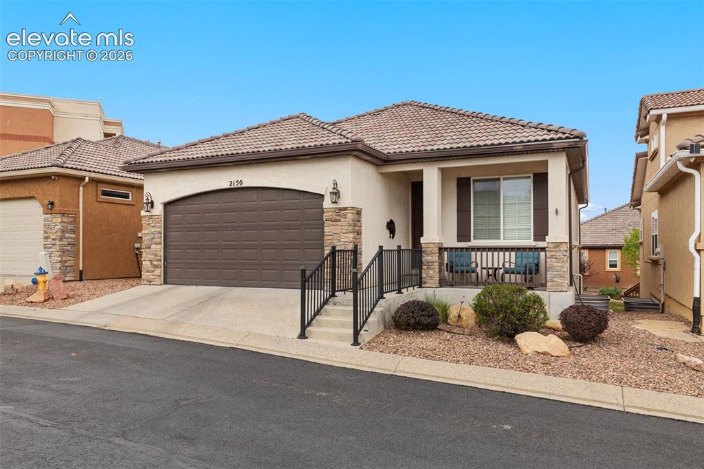 Image 1 of 28: Stucco exterior featuring a tiled roof and stone accents