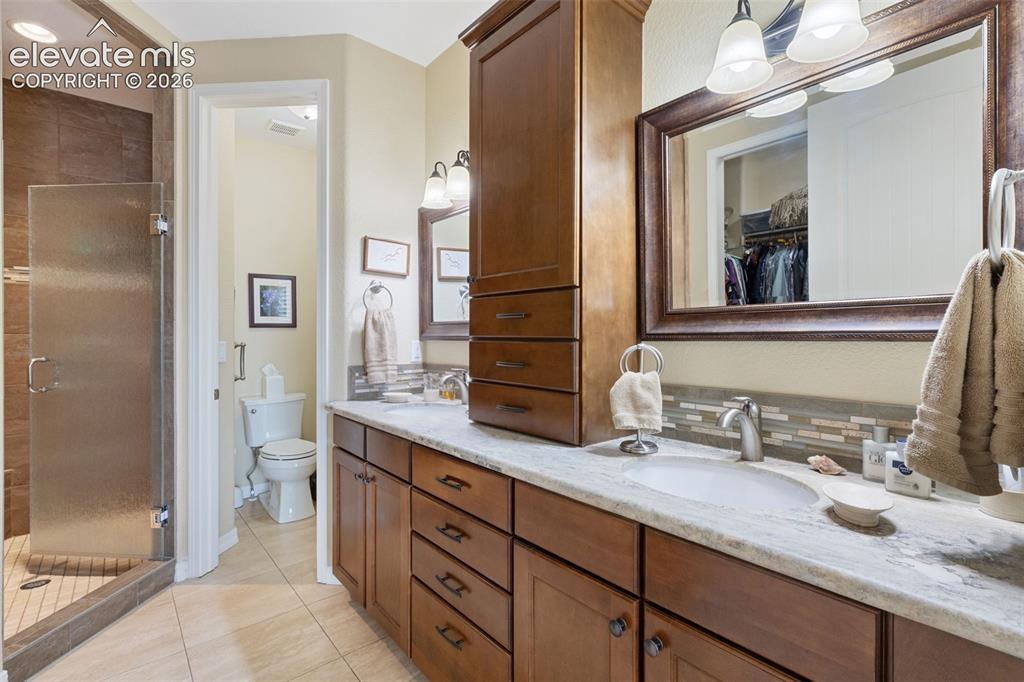 Image 10 of 28: Dual vanity with birch cabinetry.