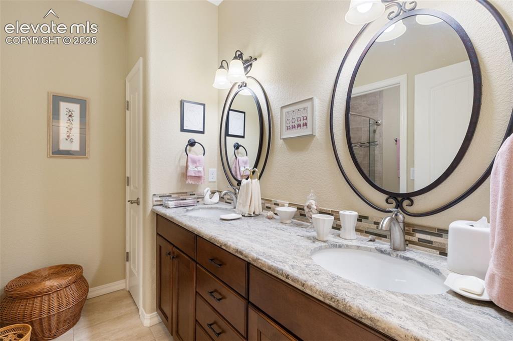 Image 11 of 28: Dual vanity featuring a light-toned granite countertop, undermount sinks, b